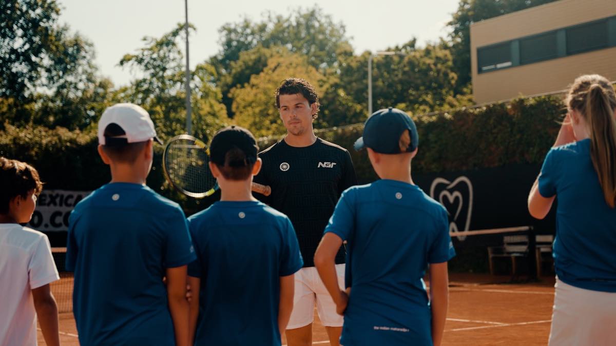 Trainer met een groep tenniskids